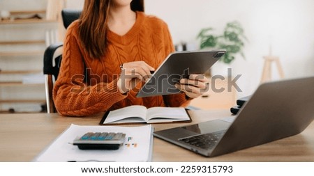 Confident businesswoman working on laptop,tablet and tablet at her workplace at office.