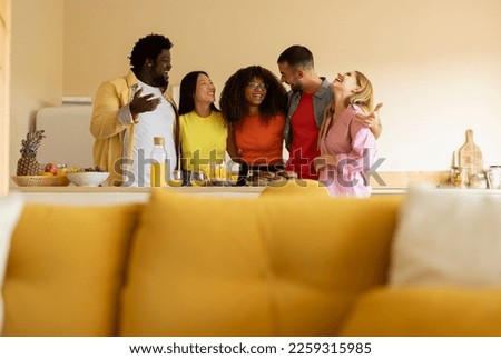 group of multiracial friends celebrating birthday at home kitchen