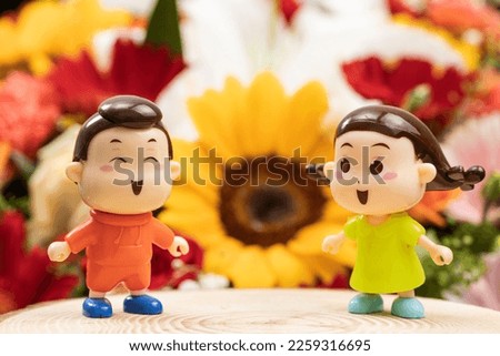 The boy and girl in front of the flowers