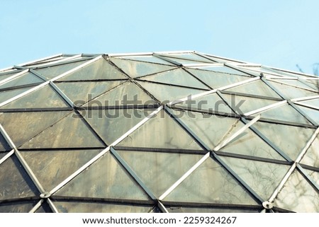 Close up glass dome of round greenhouse concept photo. Botanical garden architecture. Front view photography with blurred background. High quality picture for wallpaper, travel blog, magazine, article