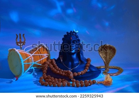 Shivaratri background with Shivas trident, Pellet Drum Damroo musical instrument ans snake . Maha Shivratri festval Royalty-Free Stock Photo #2259325943