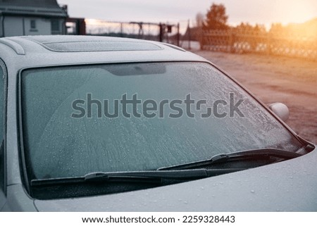 frozen windshield wiper. concept of dangerous driving during the winter season. Royalty-Free Stock Photo #2259328443