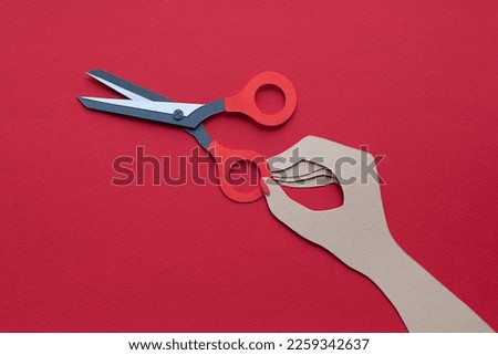 Handmade cutout scissors in hand with manicure on red background. Pop art and cartoon comic style. 