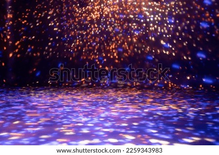 blurred rays of light on disco floor. orange violet blue neon searchlight lights. laser lines and lighting effect. night empty stage in studio with neon reflections. scene dark abstract background Royalty-Free Stock Photo #2259343983