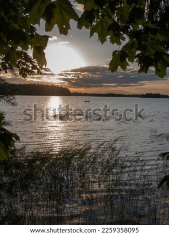 Beautiful summer lake sunset landscape with lonely boat