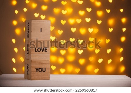 wooden cubes I Love You on a blurred background of hearts close-up