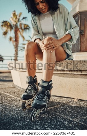 Knee pain, roller skater injury and woman in city after accident or fall outdoors. Sports, training and black female with fibromyalgia, inflammation or painful leg after skating practice on street.