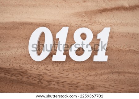 White number 0181 on a brown and light brown wooden background.