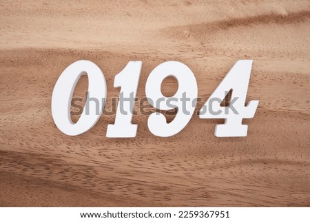 White number 0194 on a brown and light brown wooden background.