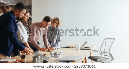 Creative team brainstorming with sticky notes in an advertising agency. Group of business people discussing ideas in a meeting. Business professionals collaborating on a project. Royalty-Free Stock Photo #2259371061