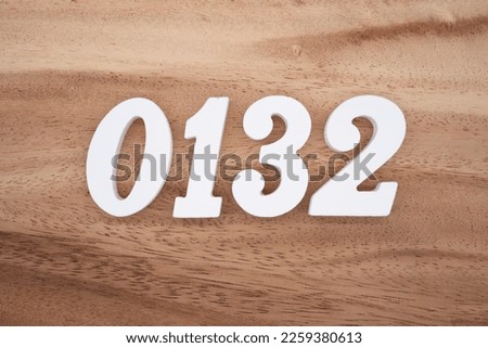 White number 0132 on a brown and light brown wooden background.