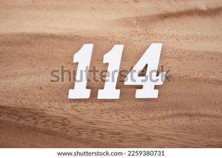 White number 114 on a brown and light brown wooden background.
