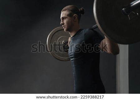 Portrait of caucasian athlete working out with barbel at crossfit gym. Functional circuit training with crossfit equipment. Copy space Royalty-Free Stock Photo #2259388217