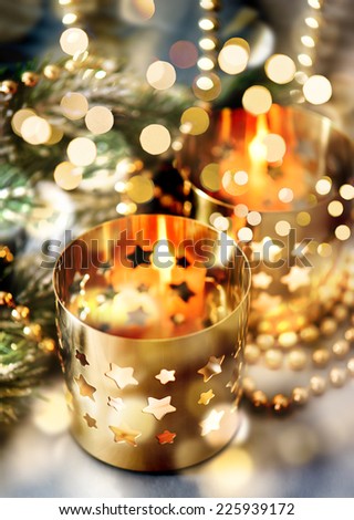 christmas decoration with burning candles, lanterns and golden lights. dark designed picture. selective focus
