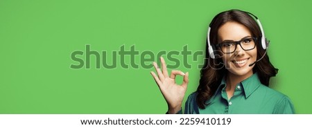 Face portrait of customer support phone operator, woman in eye wear glasses, headset doing okay ok zero hand sign gesture, isolate shamrock green background. Consulting assistance service call center