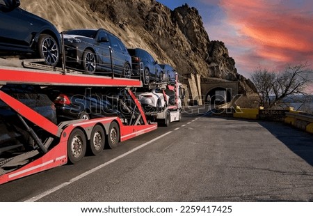 Big car carrier truck. A truck loaded with cars crosses a mountainous area. No logo, brand. Royalty-Free Stock Photo #2259417425