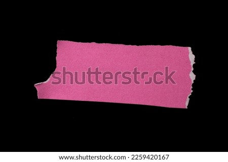 Pink torn paper piece isolated on black background with copy space for text