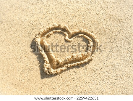 heart is drawn on the beach sand. Painted heart on the sand