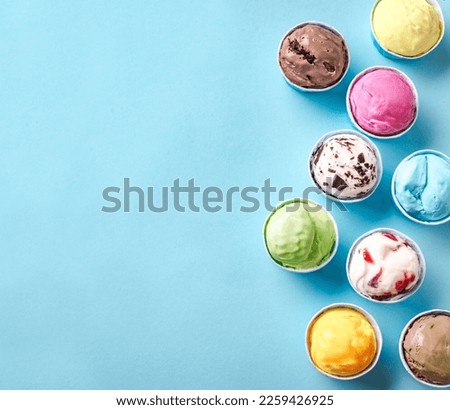 Ice Cream Assortment. Various ice creams or gelato on blue background, copy space. Frozen yogurt  in small paper cups - healthy summer dessert.