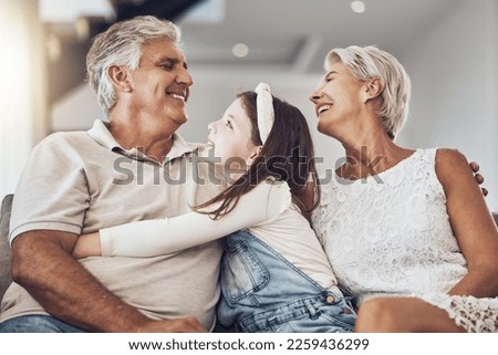 Relax, love or grandparents hug a girl in living room bonding as a happy family in Australia with care. Retirement, smile or elderly man relaxing old woman with child at home together on fun holiday Royalty-Free Stock Photo #2259436299