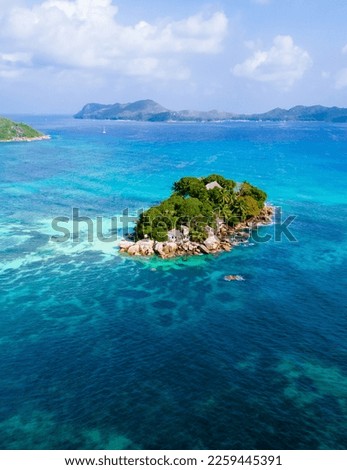 Drone view from above at a tropical beach in Seychelles. Anse Volbert beach Praslin with granite boulders rocks