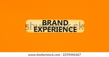 Brand experience symbol. Concept words Brand experience on wooden stick. Beautiful orange table orange background. Business branding and brand experience concept. Copy space.