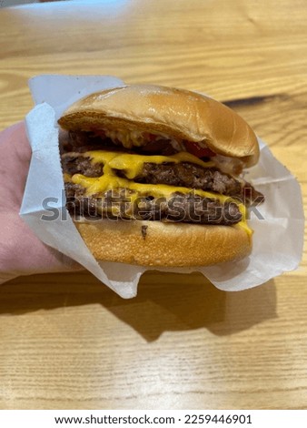 Take Away Double Cheeseburger Hand Hold Take Out at Fast Food Restaurant. Ready to Bite.