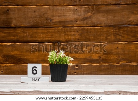 May calendar with number  6. Planner copy space on a wooden brown background. March number icon. Place for text background calendar