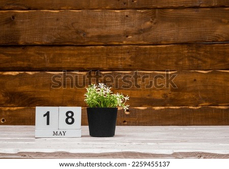 May calendar with number  18. Planner copy space on a wooden brown background. March number icon. Place for text background calendar