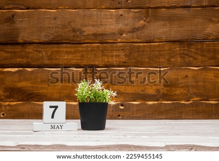 May calendar with number  7. Planner copy space on a wooden brown background. March number icon. Place for text background calendar