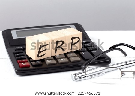 ERP concept on wooden cubes on a calculator on white background