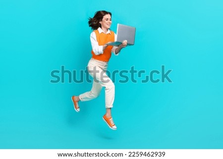 Full body photo of attractive programmer office worker girl hold netbook order online shopping isolated jump isolated on blue color background