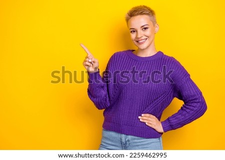 Photo of good mood blonde hair girl wear trendy brand purple knit sweater finger point mockup new collection isolated on yellow color background