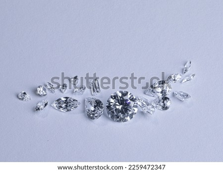 Close up of a pare of blue and white diamonds of different cuts with shadows. Royalty-Free Stock Photo #2259472347