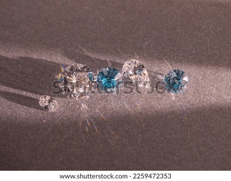 Close up of a pare of blue and white diamonds of different cuts with shadows. Royalty-Free Stock Photo #2259472353