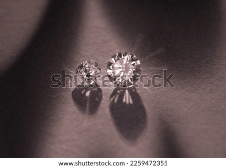 Close up of a pare of blue and white diamonds of different cuts with shadows. Royalty-Free Stock Photo #2259472355