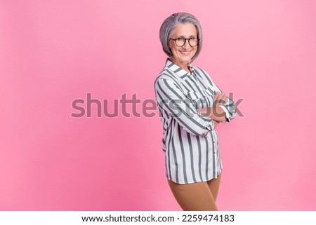 Photo portrait of cheerful attractive pensioner woman crossed hands wear striped shirt look you invite vacancy isolated on pink color background