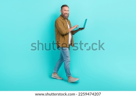 Profile side photo of good looking man use netbook modern device technology walk shop empty space isolated on cyan color background