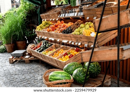 Fruit stand at a street market outside with organic watermelons, oranges, lemons in wooden crates small business vegan healthy food selective focus  Royalty-Free Stock Photo #2259479929