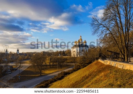 Orthodox church cathedral in Ukraine in Europe in the city near the road near the park with trees and branches on a sunny day against the background of the sky with clouds