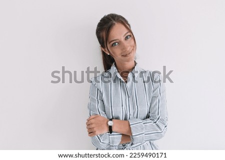Close up indoor photo of attractive pretty stylish woman with big blue eyes posing to camera while standing against isolated background. 