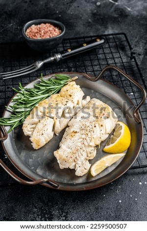 Roast Fillets of codfish, cooked cod fish meat. Black background. Top view.
