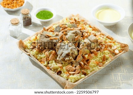 Jordanian mansaf dish with sauce (jabbaj), with fatteh yellow rice and nuts on a white background, copy space 9 Royalty-Free Stock Photo #2259506797