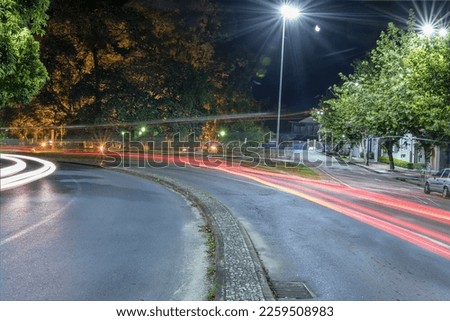 Car traffic lights at night on the curve of Avenida Francisco Sales near Affonso Junqueira park. Poços de Caldas, Minas Gerais, Brazil. Long exposure photography.