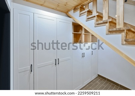 The remaining space under the stairs leading to the basement was made into a storage cabinet Royalty-Free Stock Photo #2259509211