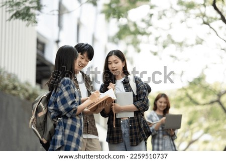 Group of young Asian college students are studying together in university. Students outdoors. Education concept.

