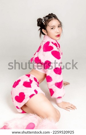 Young Pretty Asian woman have prefect slim fit body in heart print dress with makeup on face sitting isolated on white background. Valentine, love, plastic surgery concept.