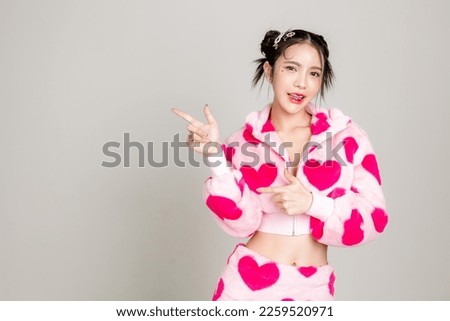 Young Pretty Asian woman have prefect slim fit body in heart print dress with makeup on face pointing finger to copy space isolated on white background. Valentine, love, plastic surgery concept. Royalty-Free Stock Photo #2259520971