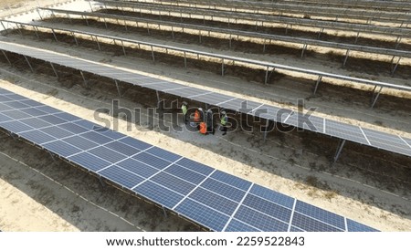 Low angle view of technician walks with investor through field of solar panels, Alternative energy to conserve the world's energy, Photovoltaic module idea for clean energy production. Türkiye