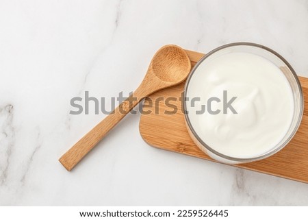 Creamy natural yogurt on a light background, Probiotic cold fermented dairy drink. Long banner format. top view,